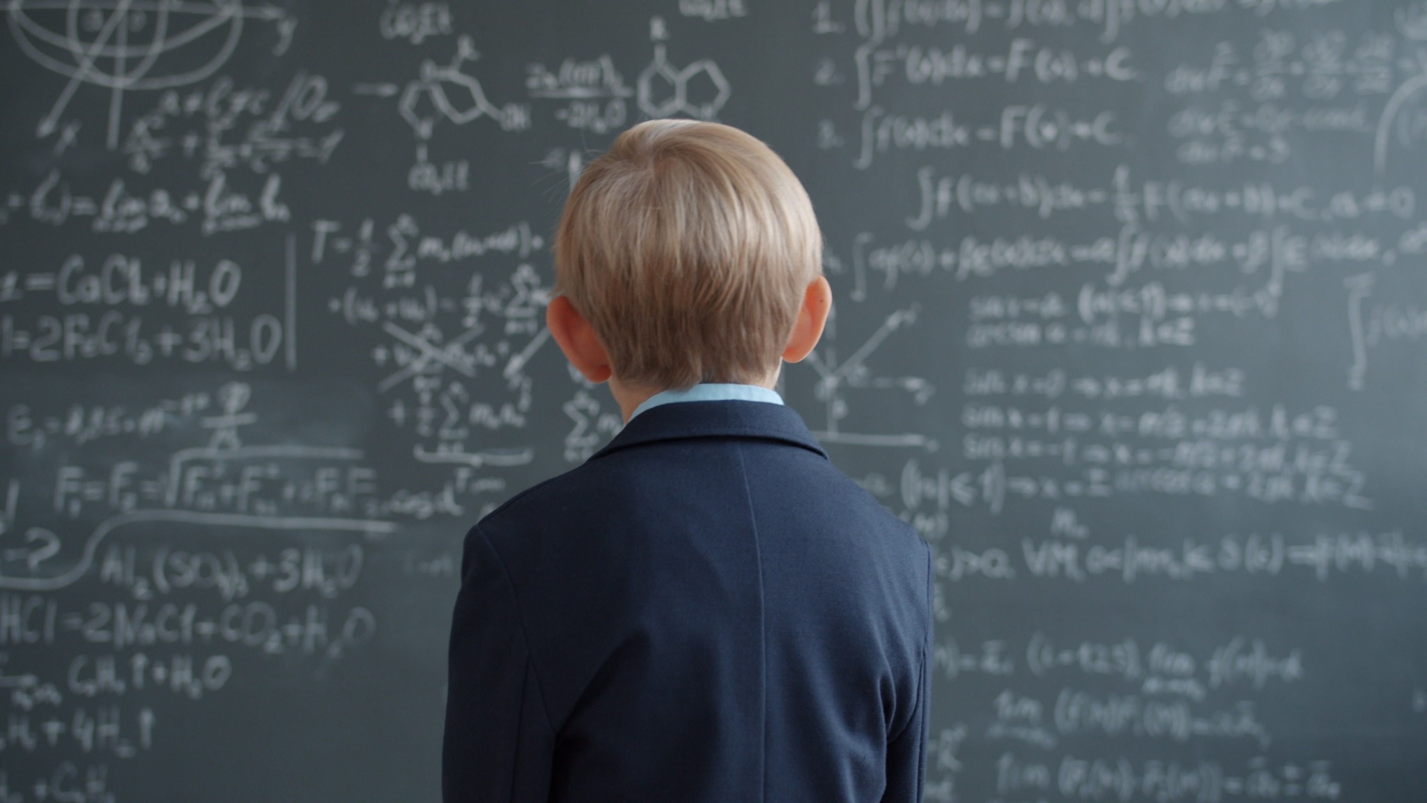 Student working through mathematics on a chalkboard