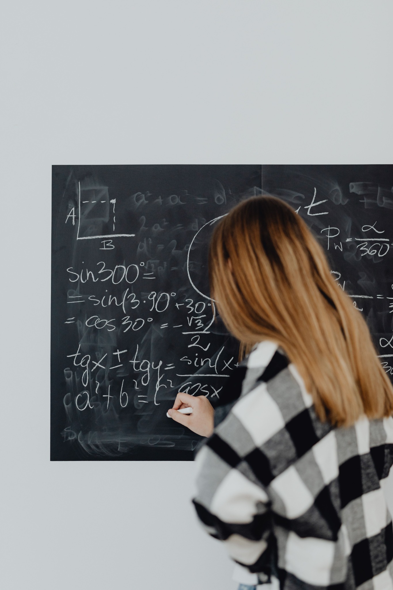 Student working through mathematics at a chalkboard